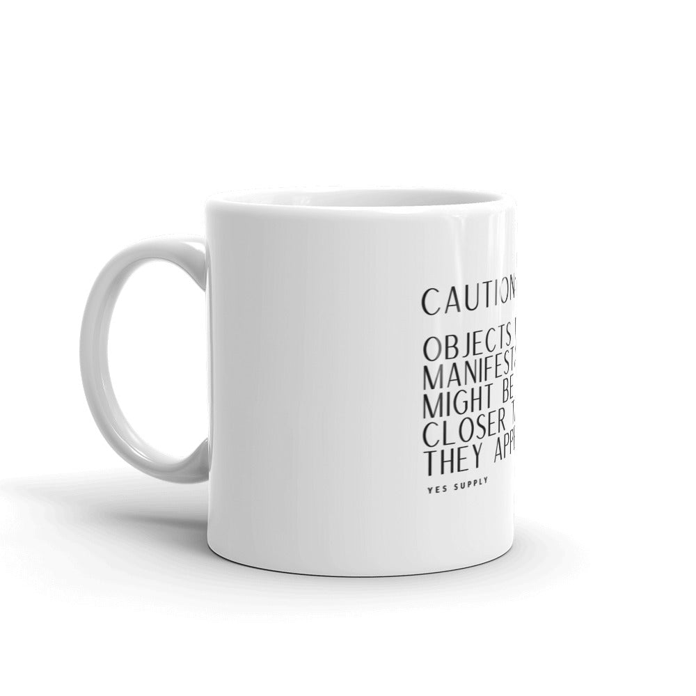 CAUTION: Objects In Manifestation Mug