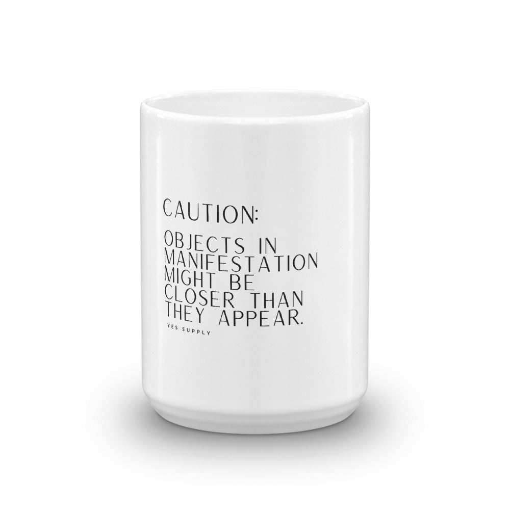 CAUTION: Objects In Manifestation Mug
