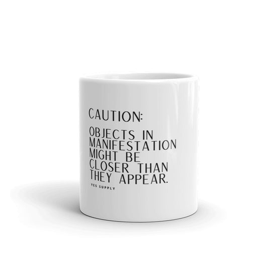 CAUTION: Objects In Manifestation Mug